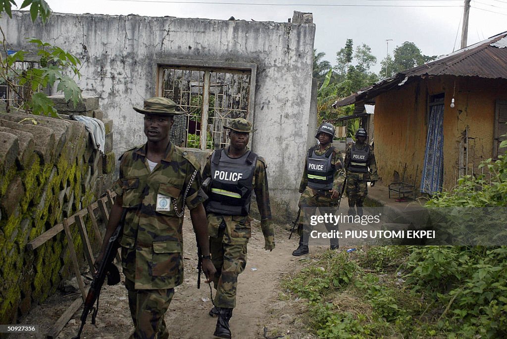 Military policemen walk past a building