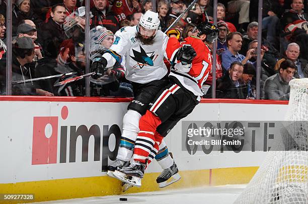 Brent Burns of the San Jose Sharks and Richard Panik of the Chicago Blackhawks get physical in the second period of the NHL game at the United Center...