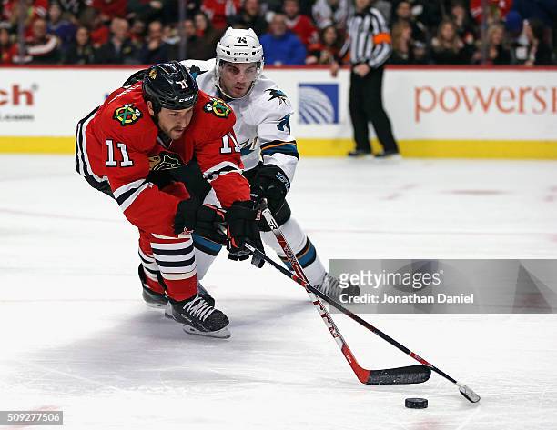 Andrew Desjardins of the Chicago Blackhawks battles for the puck with Dylan DeMelo of the San Jose Sharks at the United Center on February 9, 2016 in...