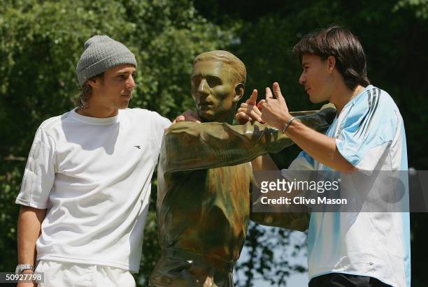 Gason Gaudio and Guillermo Coria of Argentina pose for pictures at the Jacques Brugnon statue prior to their men final match tomorrow during Day...
