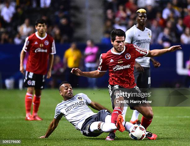 Ashley Cole of the Los Angeles Galaxy attempts to kick the ball from Hiram Munoz of Club Tijuana during the first half at StubHub Center on February...