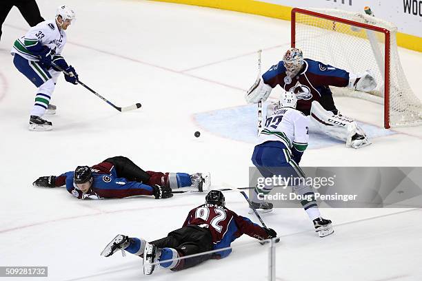 Daniel Sedin of the Vancouver Canucks passes the puck to Henrik Sedin of the Vancouver Canucks as Gabriel Landeskog of the Colorado Avalanche and...