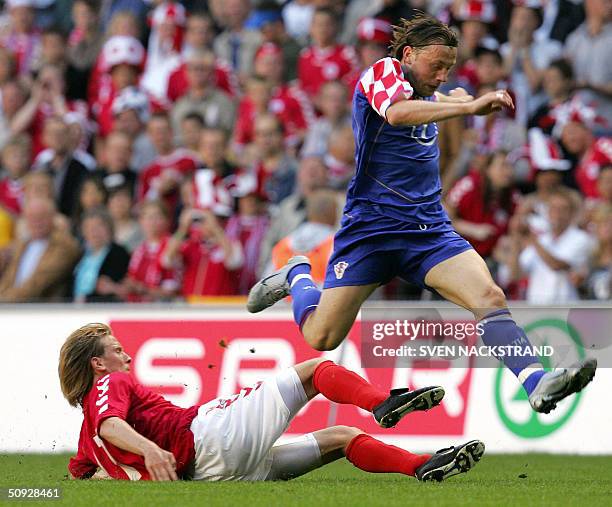 Croatia's Ivica Olic leaps over the legs of Denmark's Christian Poulsen in the pre-EURO 2004 friendly football match between the two countries in...