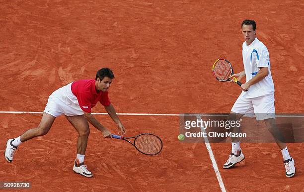 Michael Llodra and Fabrice Santoro of France return serve in their mens doubles final match against Xavier Malisse and Olivier Rochus of Belgium...