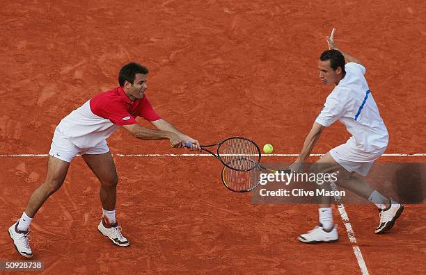 Michael Llodra and Fabrice Santoro of France return serve in their mens doubles final match against Xavier Malisse and Olivier Rochus of Belgium,...