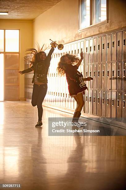 girls leaping in school hallway with instruments - music halls foto e immagini stock