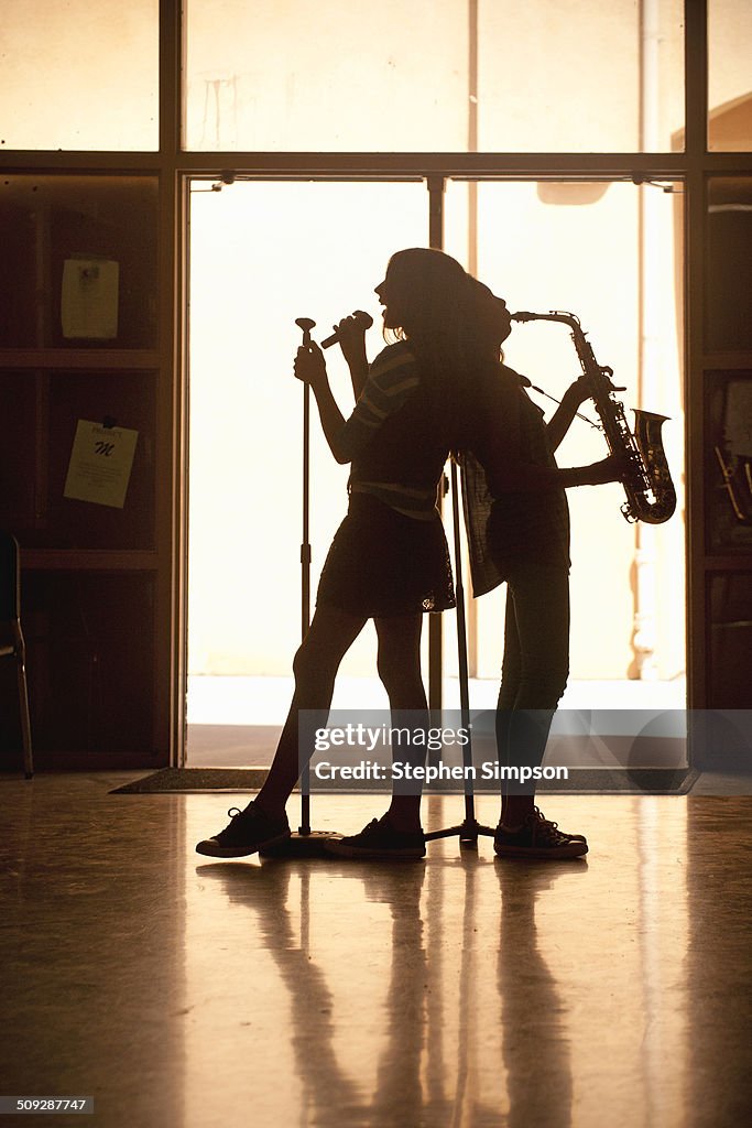 Teen girls practicing their music in hallway