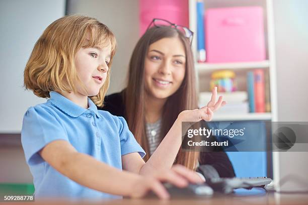 trainee teacher listening to schoolgirl - t shirt uniform stock pictures, royalty-free photos & images