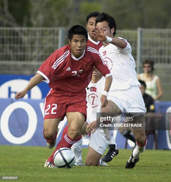 Chinese player Junmin Hao fights for the ball with Turkish player 05 June 2004, at Cauvin stadium in Lorgues, during the under 21's International...