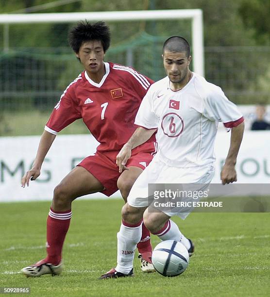 Turkish players Adem Kocak fights for the ball with Chinese player Shouting Wang 05 June 2004, at Cauvin stadium in Lorgues, during the under 21's...