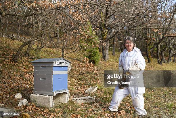 female beekeeper smoking her hive named 'resolution' - weird hobbies stock pictures, royalty-free photos & images