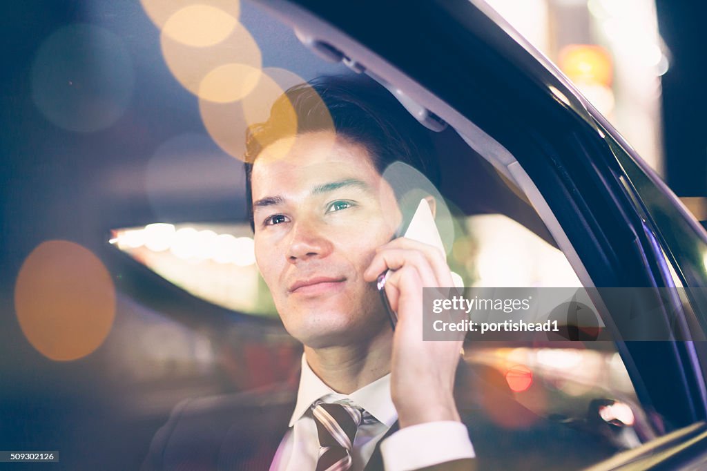 Asian businessmen at back seat of car