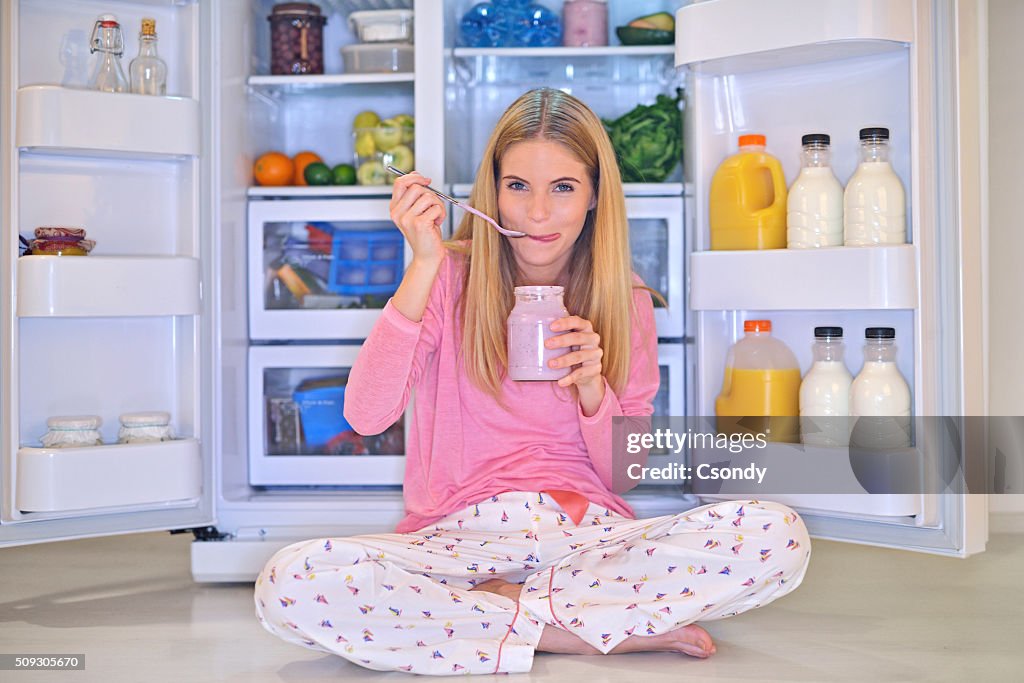 Mujer joven comiendo yogur