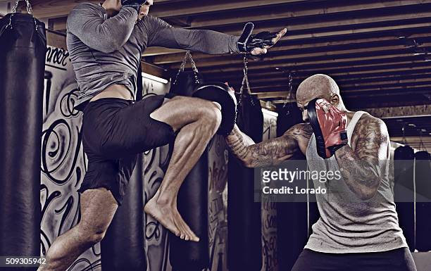 two fighters sparring at an urban boxing gym - mixed martial arts stock pictures, royalty-free photos & images