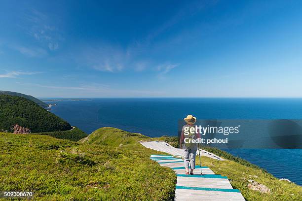 mujer de caminatas, paseos de excursionismo de los edificios, cabot sendero, del cabo bretón, nova escocia - atlantic ocean fotografías e imágenes de stock