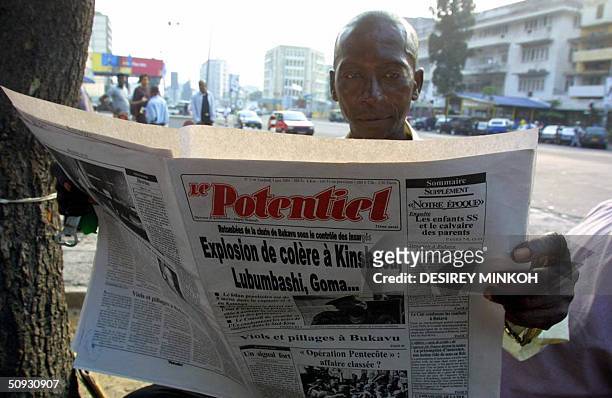 Man reads the Congolese newspaper Le Potentiel titling "Burst into anger in Kinshasa, Lubumbashi, Goma..." 05 June 2004, in Kinshasa. Dissident...