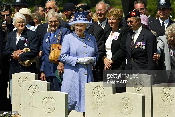 Britian's Queen Elizabeth II walks past grave stones as she greets D-Day veterans after a cermony of commemoration at the Commonwealth War Graves...