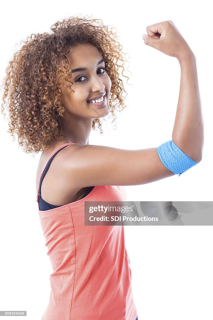 Pretty young woman showing muscles and bandage after donating blood