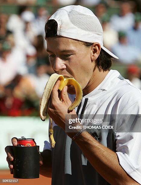 Argentinian Guillermo Coria eats a banana and drinks during his game against Argentinian Gaston Gaudio in their men's final match during the French...