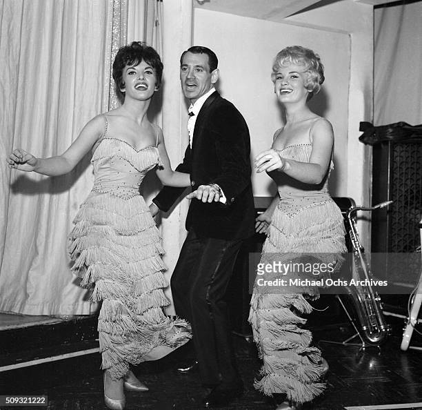 Musician and Bandleader Ray Anthony dances with two backup singers at a Los Angeles dance hall in Los Angeles,California.