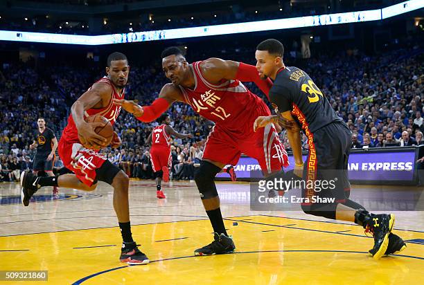 Trevor Ariza of the Houston Rockets, Dwight Howard of the Houston Rockets and Stephen Curry of the Golden State Warriors go for a loose ball at...