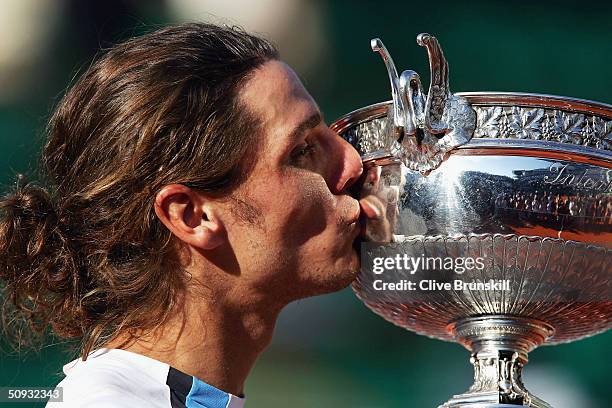 Gaston Gaudio of Argentina celebrates with the trophy after winning his mens final match against Guillermo Coria of Argentina, on Day Fourteen of the...