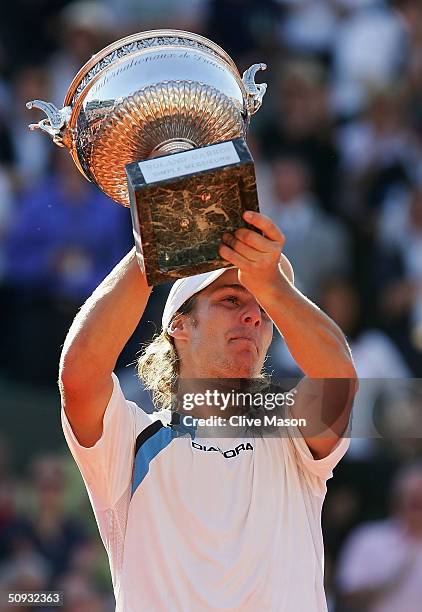 Gaston Gaudio of Argentina celebrates with the trophy after winning his men's final match against Guillermo Coria of Argentina during Day Fourteen of...
