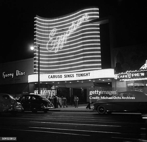 People walk past the Egyptian Theatre on Hollywood Boulevard at night in Hollywood,California.