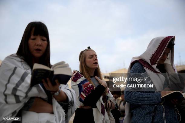 Members of the liberal religious group "Women of the Wall" wear phylacteries and "Tallit" shawls, traditional Jewish prayer apparel for men, as they...