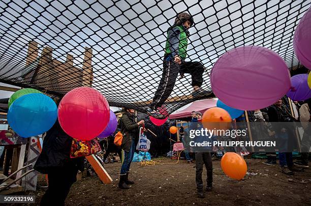 Child bounces on a trampoline at the playground of a shelter used as a school in the so-called "Jungle" migrant camp in Calais, northern France, on...