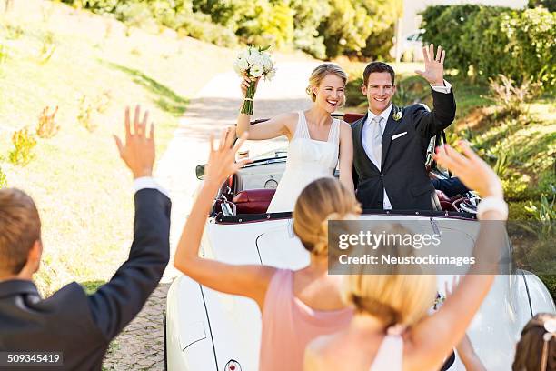 coppia in cabriolet auto di salutare gli ospiti - ceremony foto e immagini stock