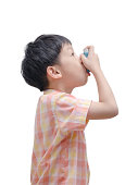 Sick Asian boy using inhaler