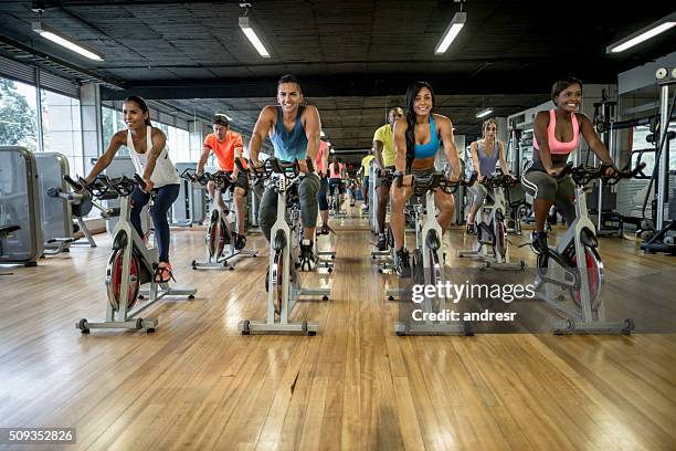 groupe de personnes faisant de l’exercice à la salle de gym - cours de spinning photos et images de collection