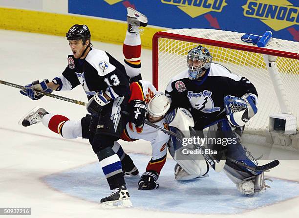 Martin Gelinas of the Calgary Flames gets tripped up between the defense of Pavel Kubina and Nikolai Khabibulin of the Tampa Bay Lightning in game...