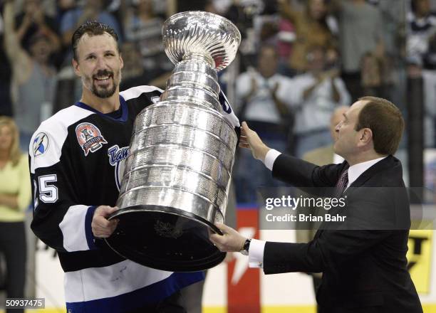 Dave Andreychuk of the Tampa Bay Lightning is presented with the Stanley Cup by NHL Commisioner Gary Bettman after defeating the Calgary Flames in...