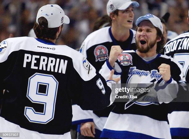 Martin St. Louis of the Tampa Bay Lightning celebrates with teammate Eric Perrin after defeating the Calgary Flames in game seven of the NHL Stanley...