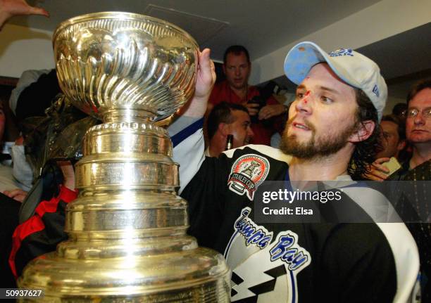 Martin St. Louis of the Tampa Bay Lightning celebrates with the Stanley Cup in the locker room after defeating the Calgary Flames in game seven of...