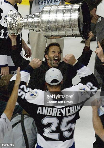 Coach John Tortorella of the Tampa Bay Lightning holds the Stanley Cup over his head while celebrating victory over the Calgary Flames with Dave...