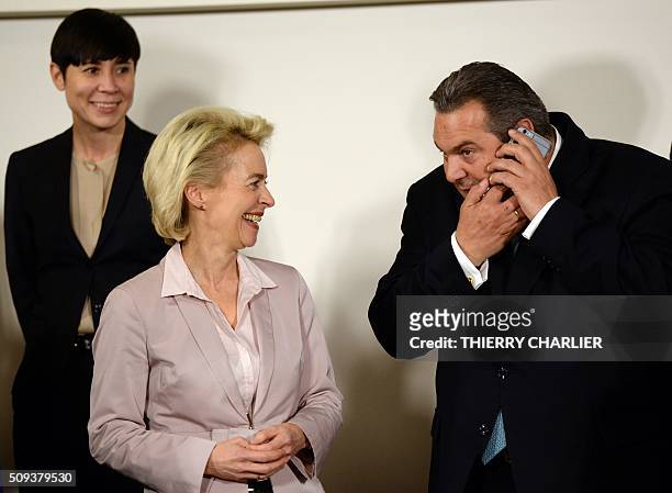 Greek Defence Minister Panos Kammenos uses his mobile phone while German Defence Minister Ursula von der Leyen and Norwegian Defence Minister Ine...