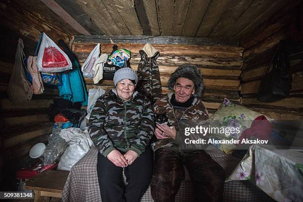 Hasiya, Kamil and their cat Marussia pose for a picture in their shack at a market near the Siberia village of Yangutum, on February 2, 2016 in...