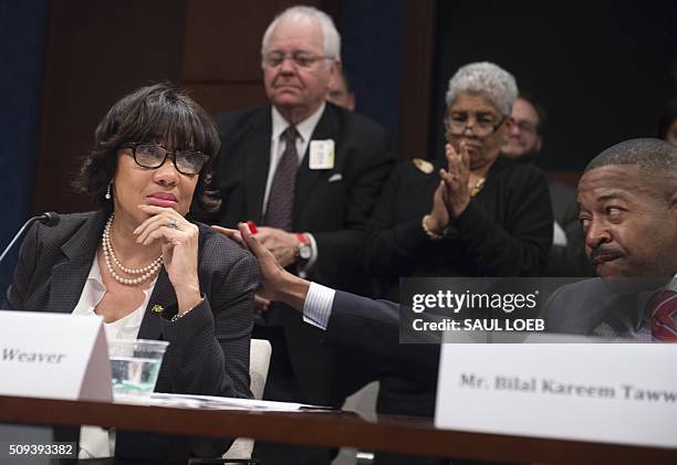 Bilal Kareem Tawwab, Superintendent of Flint, Michigan School District, places his hand on the shoulder of Mayor Karen Weaver of Flint, Michigan, as...