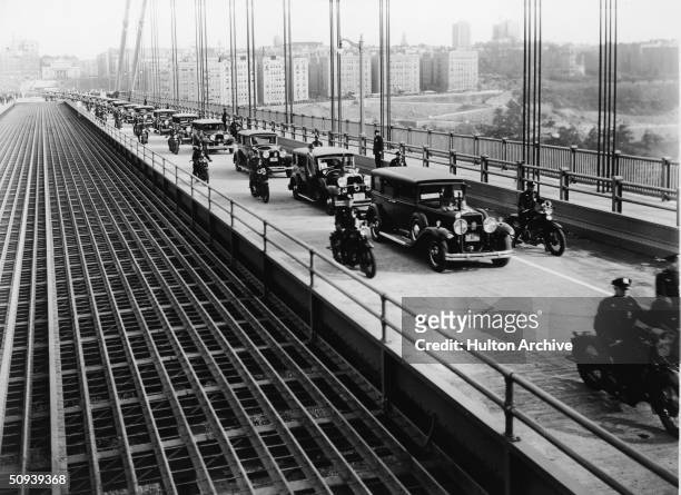 Line of cars travel over the George Washington Bridge for the first time, bearing city officials and speakers en route to the opening day ceremonies,...