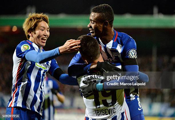 Genki Haraguchi, Vedad Ibisevic and Salomon Kalou of Hertha BSC celebrate after scoring the 1:1 during the cup match between 1. FC Heidenheim and...