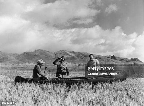 Guide Taylor Williams, photographer Robert Capa and author Ernest Hemingway pose with a canoe while on a duck hunt in Sun Valley, Idaho, November 13,...