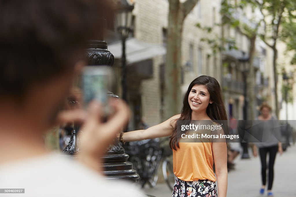 Woman posing while man photographing her