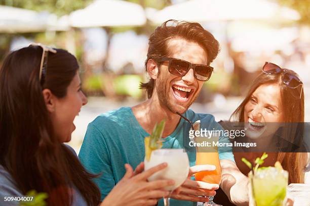 man enjoying drinks with friends at restaurant - cafeterias en la calle fotografías e imágenes de stock