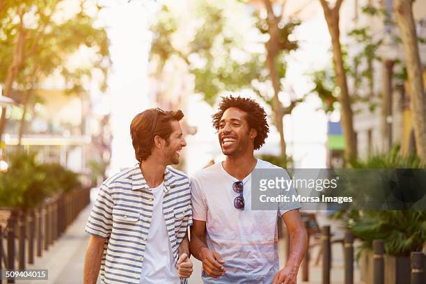 male friends walking outdoors - leisure activity fotografías e imágenes de stock