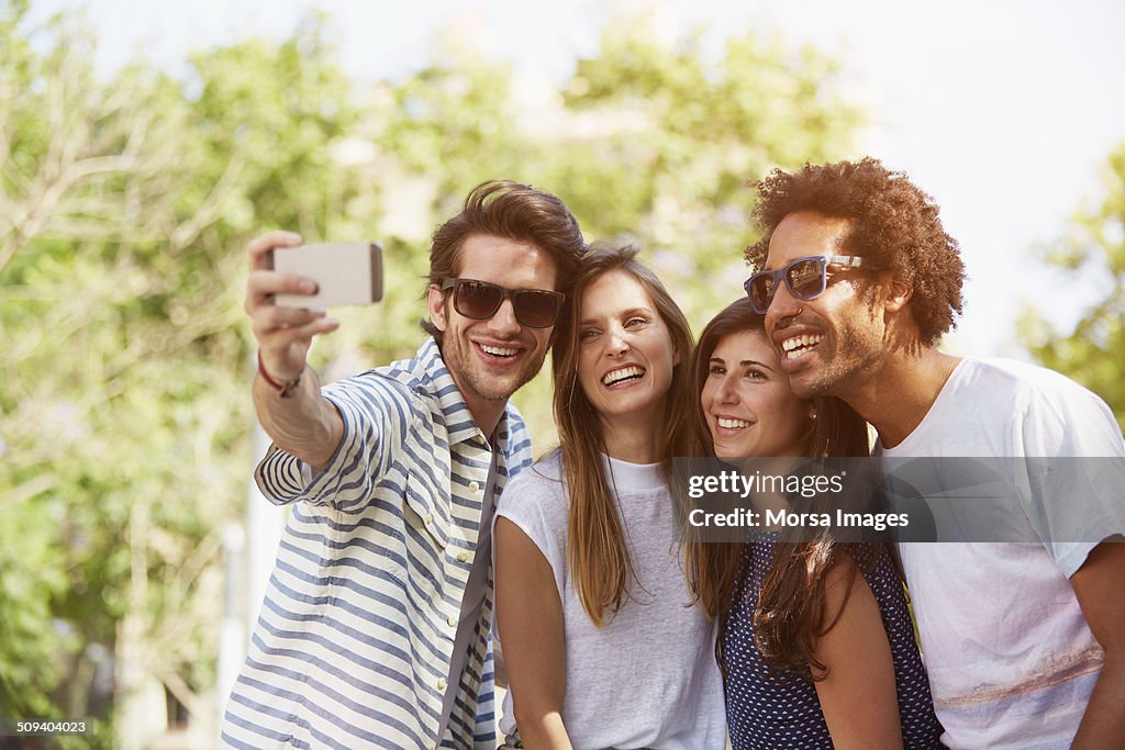 Friends taking self portrait through mobile phone