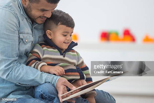 el padre de su hijo un libro de lectura - reading fotografías e imágenes de stock