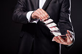 Young magician showing tricks using cards from deck. Close up.